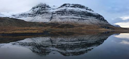 Kaldnasaborgir (986m 'cold nose rocky hill') and Skerðingsstaðafjall (661m 'Skerðings place mountain') pose as backdrop to Kirkjufellsfoss, and its glassy lake.