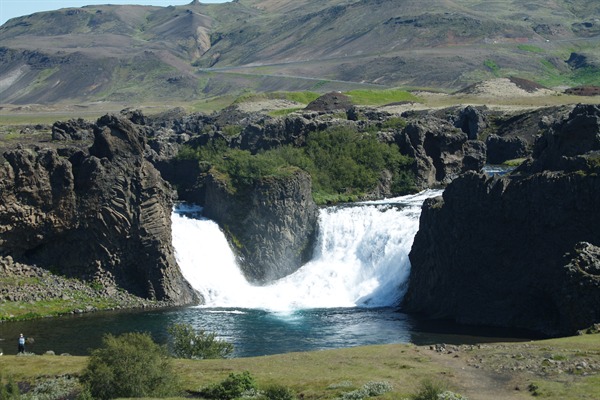 A view of Hjálparfoss in summer. [photo: <a href="http://www.south.is/en/moya/toy/index/place/hjalparfoss-waterfall" target="_blank">south.is</a>]